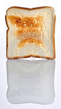 Close up of single slice of toasted bread with reflection on white surface