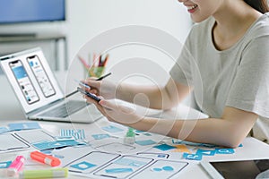 Creative ux ui designers team developing wireframe and sketching layout design mockup on smartphone screen.