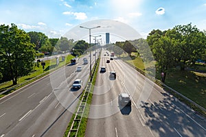 Modern highway in a green city, viewed from an overpass, with vehicles moving in both directions photo