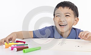 Smiling asian child schoolboy painting and drawing at home photo