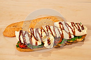 Sandwich of burrata cheese, grilled eggplant, tomato and artisan bread photo