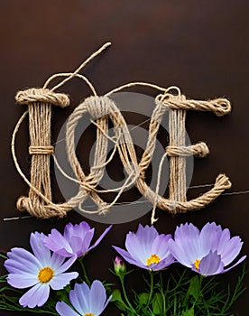 Generated image. The word love consists of a rope on a brown background. There are blue flowers at the bottom