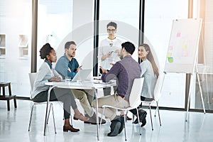 Generating ideas together. a businesswoman giving a presentation to her colleagues in a modern office.