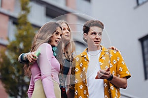 Generation z students hanging out together outdoors in the city.