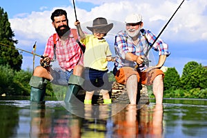 Generations men. Man with his son and father on river fishing with fishing rods. Grandpa and grandson are fly fishing on