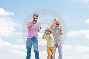 Generations of men together, portrait of smiling son, father and grandfather with a toy airplane. Child boy playing with