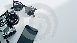 Generative AI Creative Flat lay style with film camera sunglasses and smartphone on white background with copy spa