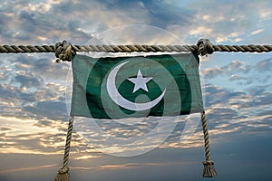 Generative AI Image of Pakistan Green Flag Hanging on Rope with Sky Background at Dusk