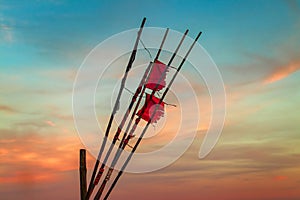 GeneratRed flags from a ship blowing in the wind at the sea under beautiful sky with setting suned Image