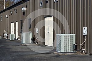 Generic Air Conditioner Compressors Behind Strip Office Building