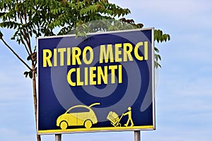 Generic billboard with written in Italian `load goods, customers` photo
