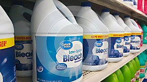 Generic bleach bottles on a supermarket shelf.
