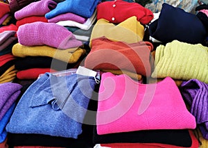Colourful cashmere folded pullovers on an outdoors market stall photo