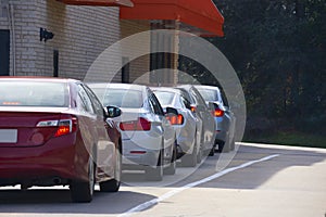 Generic drive thru pickup window with cars waiting in line to get their products or food
