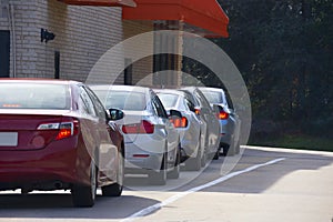 Generic drive thru pickup window with cars waiting in line to get their products or food photo