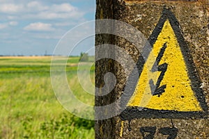 Generic High Voltage Danger Sign on an old electric pillar. Yell