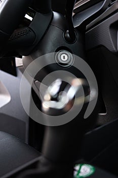 Generic metal car ignition lock on black plastic steering column close up shot no key