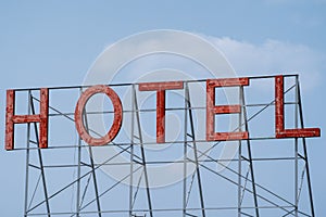 Generic red neon sign for a hotel, against a blue sky