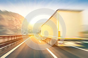 Generic semi trucks speeding on the highway at sunset