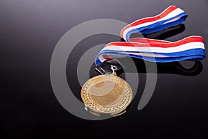 Generic sporting event gold medal with red and blue ribbon