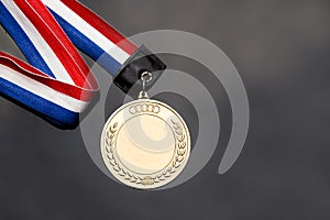 Generic sporting event gold medal with red and blue ribbon