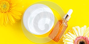 Generic white cream jar and glass serum on yellow background