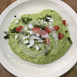 A generous amount of guacamole with onions, tomatoes, and cilantro - GUAC