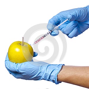 Genetic injection into apple isolated on white background. Genetically modified fruit and syringe