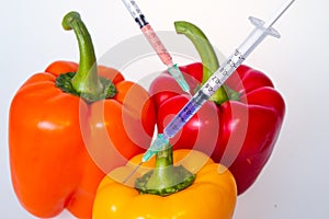 Genetically modified vegetables. GMO food concept. Syringes are stuck in vegetables with chemical additives. Injections into fruit