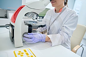 Geneticist examines under microscope sample of biomaterial for DNA test