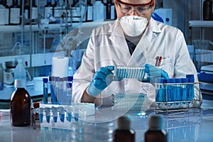 Geneticist holding multi well plate for genetic analytical in the clinical laboratory photo