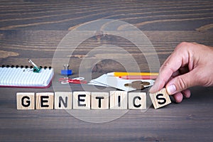 Genetics. Wooden letters on dark background