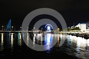 Geneva, Switzerland 8 September 2023: Night riverside view with beautiful reflections of Geneva city, Switzerland