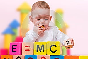 Genius baby with high IQ is playing with cubes and writing formula