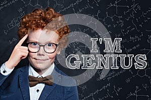 Genius child on blackboard background with science and maths formulas