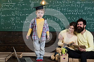 Genius child in graduation cap. Little genius answer hometask in classroom. Family proud of genius son. Genius without photo