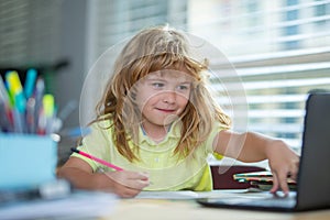 Genius nerd pupil child has idea. Child writing at school. School boy doing homework writing and reading at home