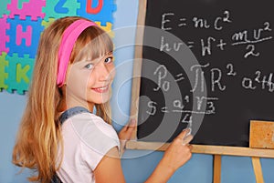 Genius schoolgirl writing on blackboard