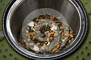 Genmaicha, Japanese tea in a tea infuser of a iron cast teapot photo