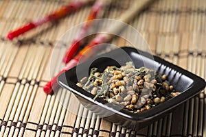 Genmaicha tea in black plate photo