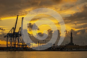 View of Lanterna lighthouse in the port of the city of Genoa at sunset with cloudy sky, Italy