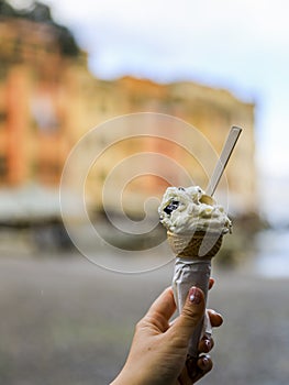 Genoa,northern Italy on April3,2023:Tasting gelato with colourful buildings of Portofino in the background