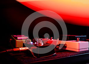 Gent Belgium - December 3 2020: Variety of guitar pedals in a home studio. Red lights. photo