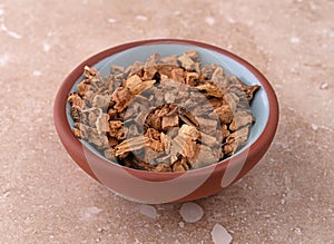 Gentian root in a small bowl on a marble table