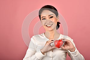 Gentle asian woman holding red heart, Happy smiling girl showing love sign to support and encourage.