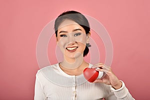 Gentle asian woman holding red heart, Happy smiling girl showing love sign to support and encourage.