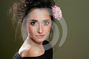 Gentle beauty portrait of beautiful young female. Girl dressed in black shirt. Gentle makeup. Woman look at camera.