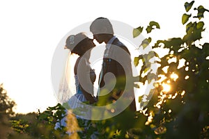 Gentle couple holding hands on background leaves and sunset