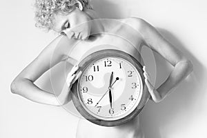 Gentle curly girl with big clock in hands.