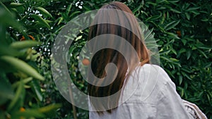 Gentle girl walking botanic garden closeup. Brunette lady looking camera alley